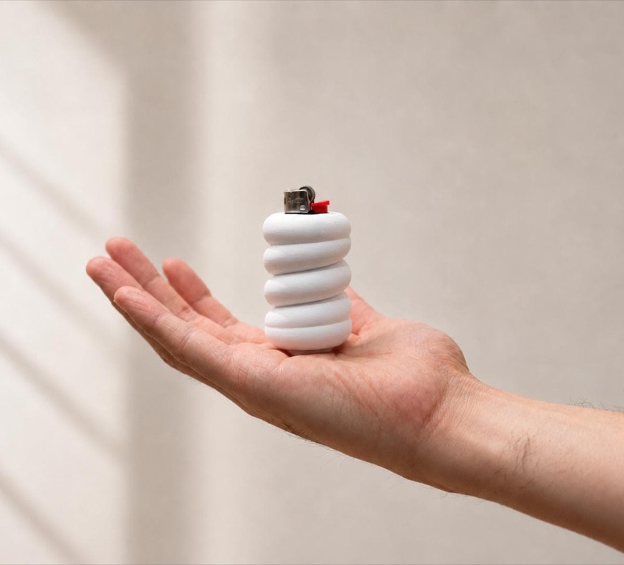 the coil lighter cover, white stacked rings held in an open palm