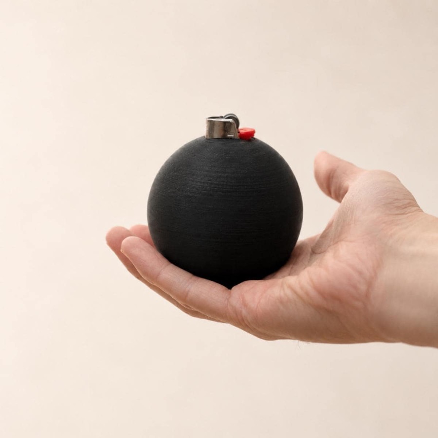 the orb lighter cover, a matte black sphere resting in an open palm